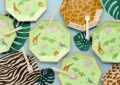 zielone ośmiokątne talerzyki papierowe safari z drewnianymi widelcami i liśćmi monstery